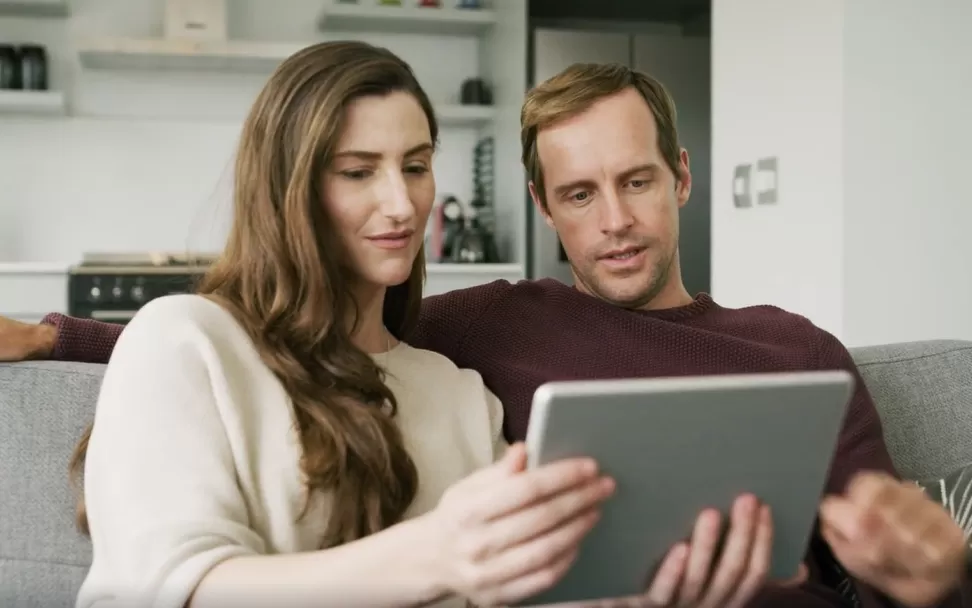 Couple reviewing HELOC interest only payment information on a tablet.