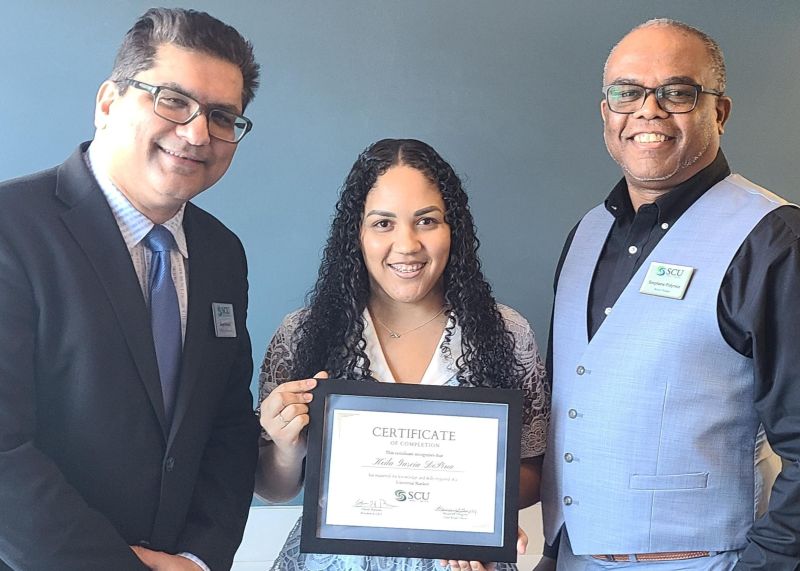 Keila receiving Universal Banker Certificate from Sarge and Stephane