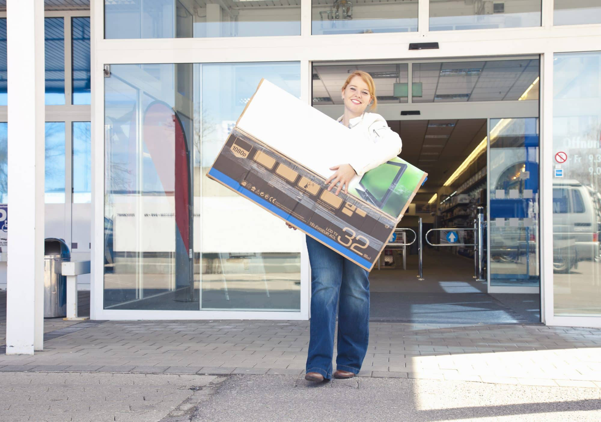 woman leaving store with large purchase